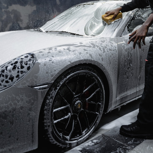 white porsche windscreen getting washed by a professional car detailer in london.